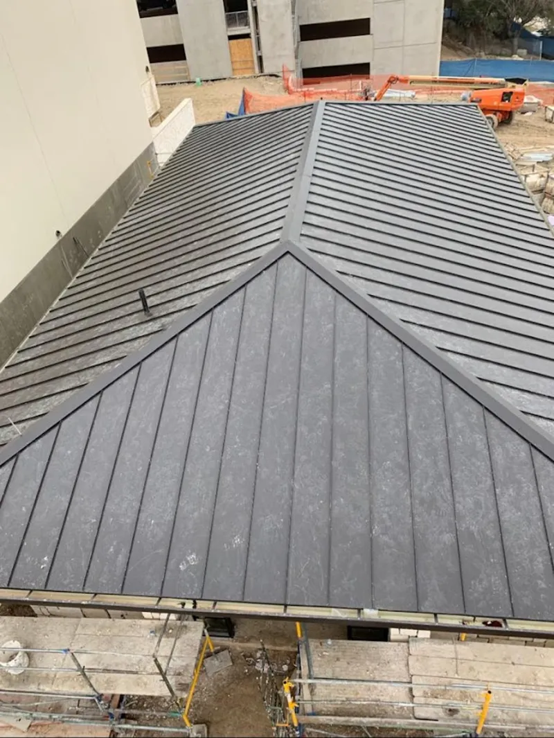 Commercial metal roof construction with crane equipment in Independent Hill